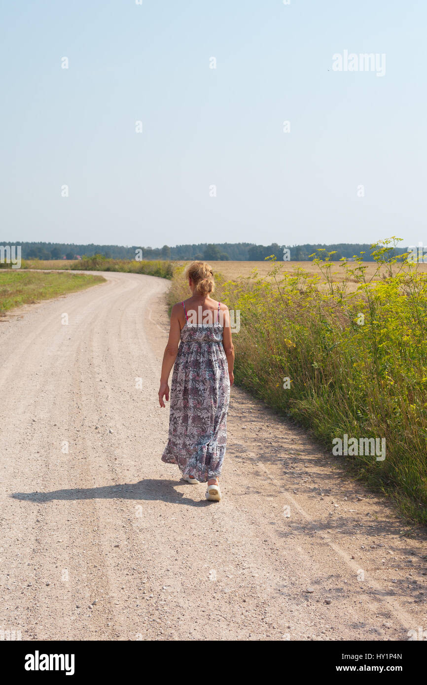 Walking woman on country road Stock Photo - Alamy
