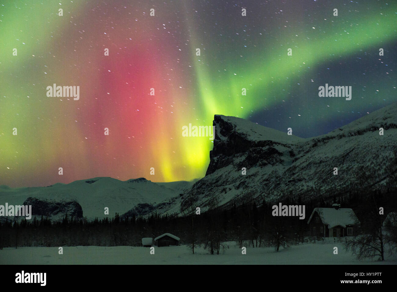 Northern light, Aurora borealis,  over Sarek national park taken from Aktse, with an old barn and house, Mount Skerfe and Namatj, slightly movement in Stock Photo