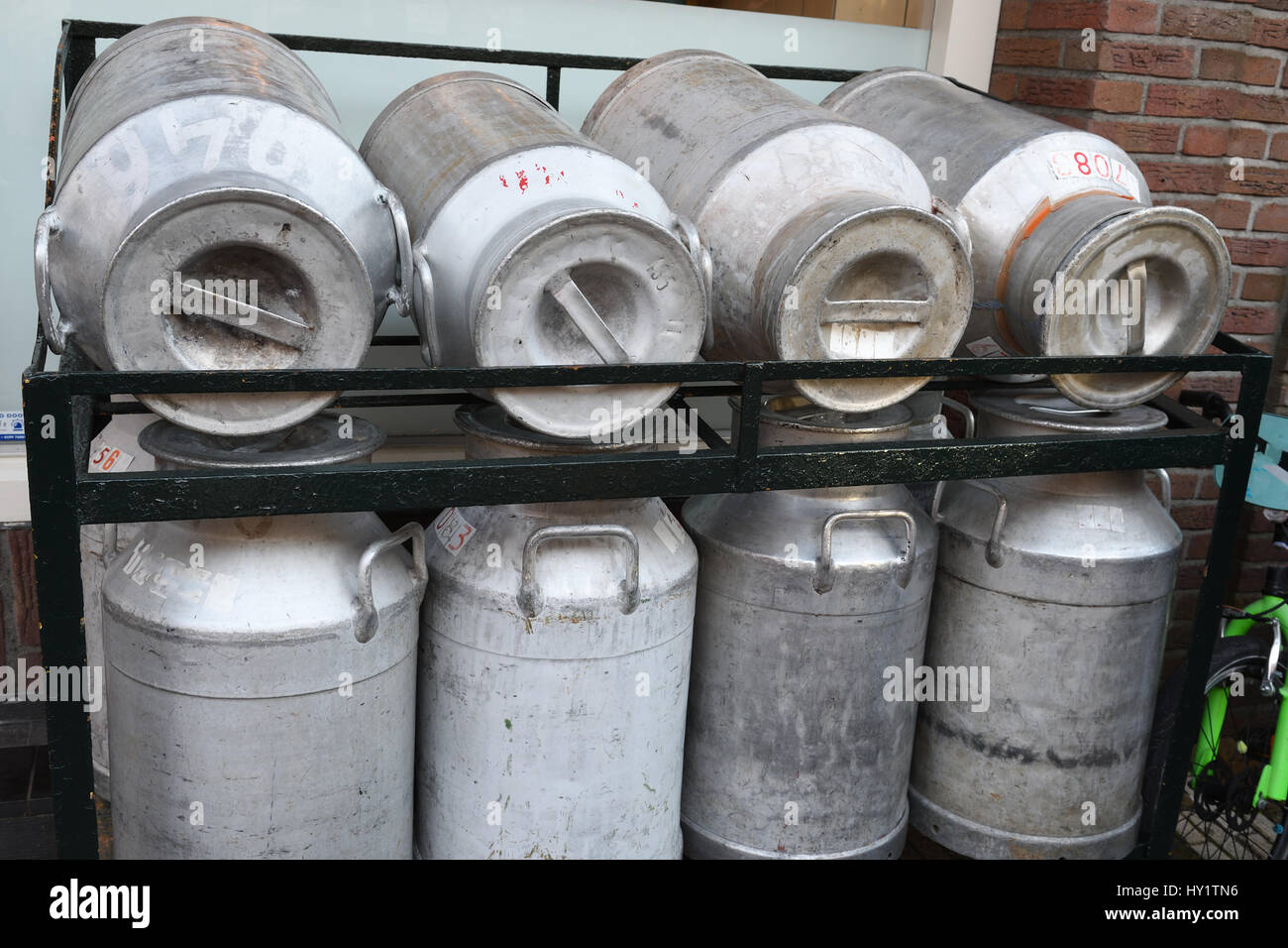 metal milk canisters on metal rack Stock Photo