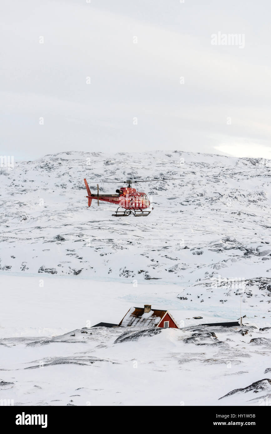 A tourist helicopter landing in the tiny inuit settlement of Oqaatsut in west Greenland Stock Photo