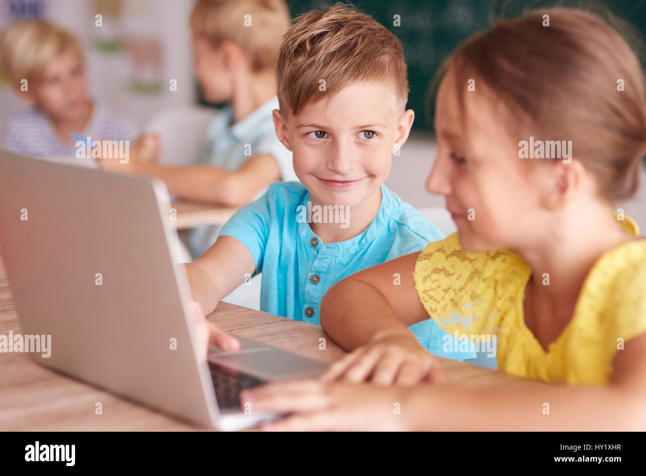 Girl and boy using the computer in the classroom Stock Photo