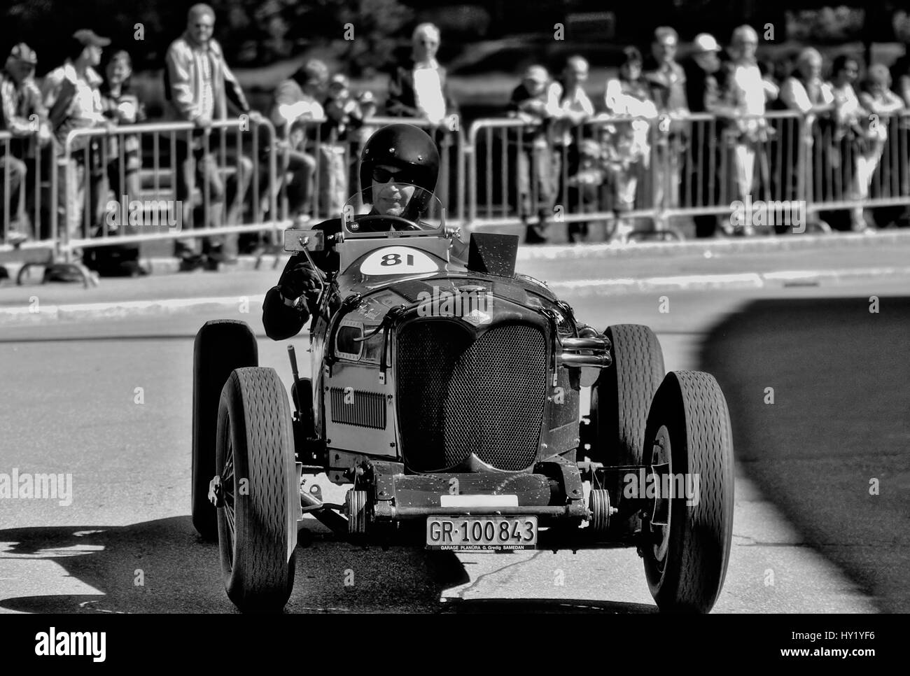 This black and white stock photo shows a vintage Riley vintage car racing during the Arosa Mountain Rally in Switzerland. The image was taken on a sli Stock Photo