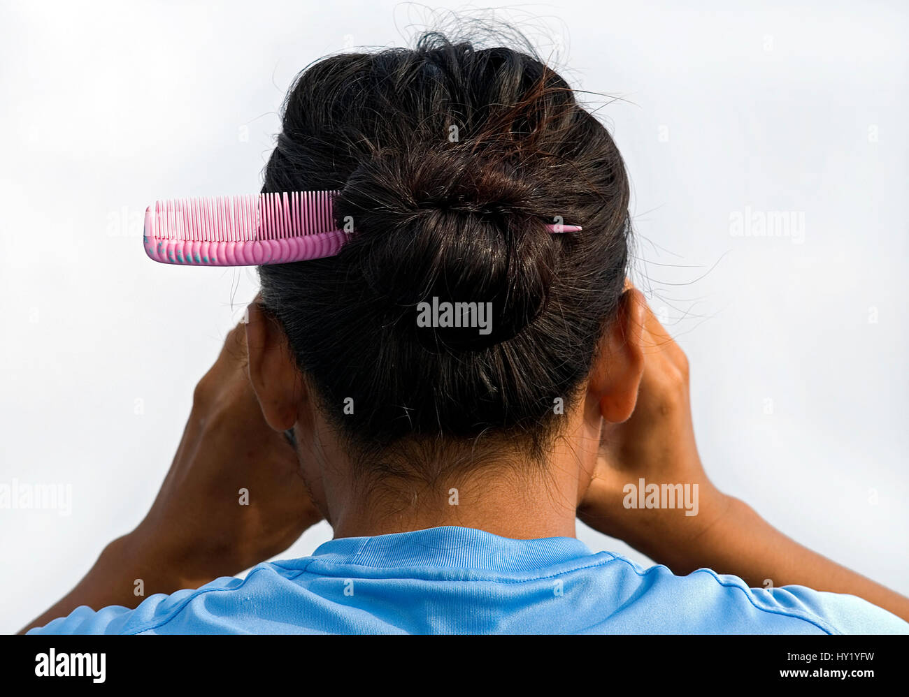 This stock photo shows a Thai Ladyboyand his hair from behind, looking through binoculars. The image was taken on a sunny afternoon. Stock Photo