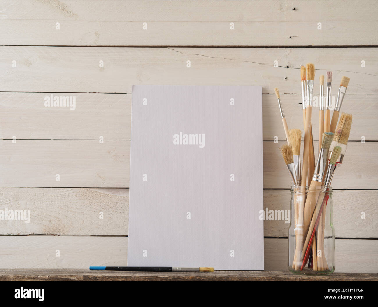 Paint brushes with a canvas on a white barn wood background Stock Photo ...