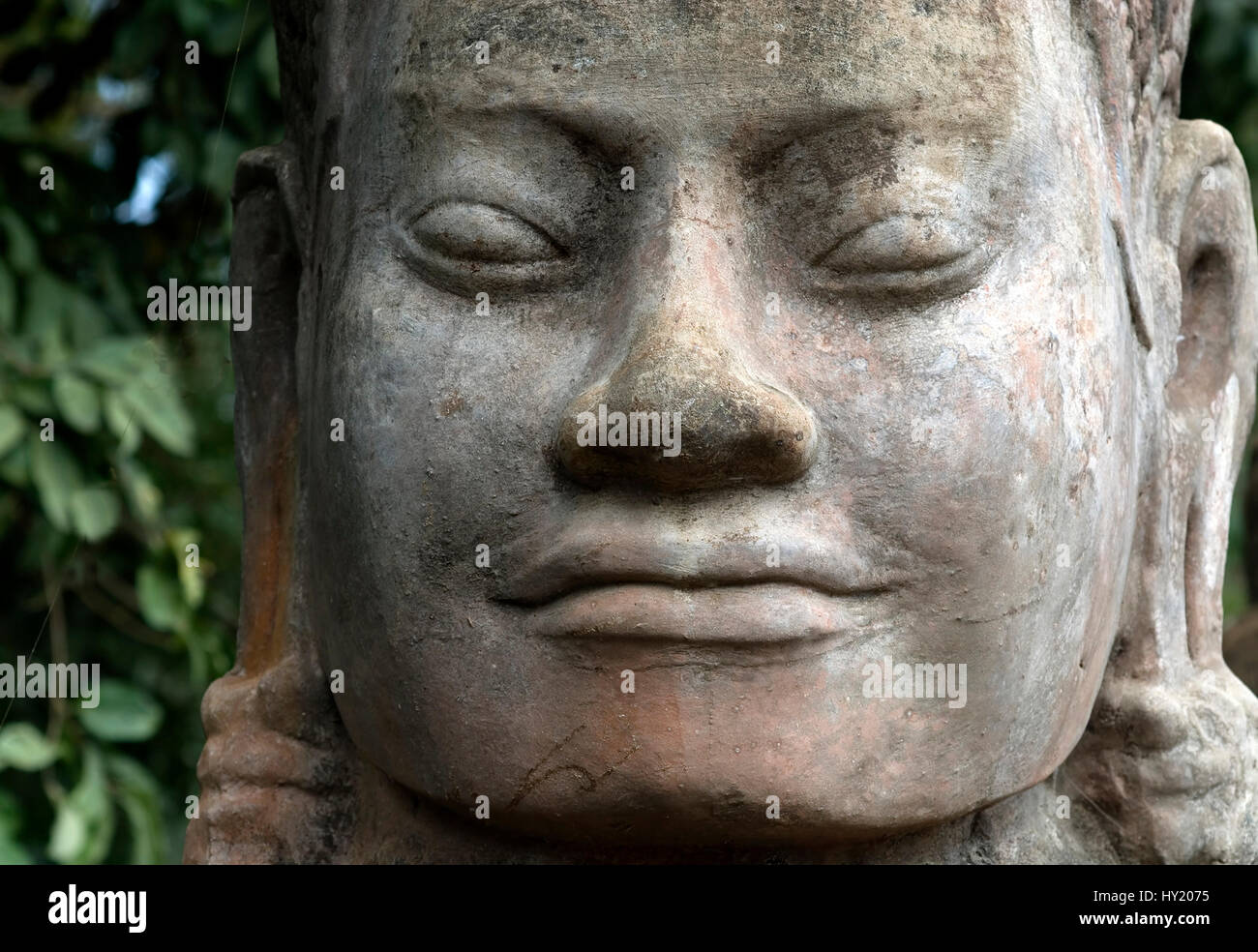 This stock photo shows a close up of a temple stone sculpture at the famous Angkor Wat Temple near Siam Reap in Cambodia. The image shows the heads wi Stock Photo