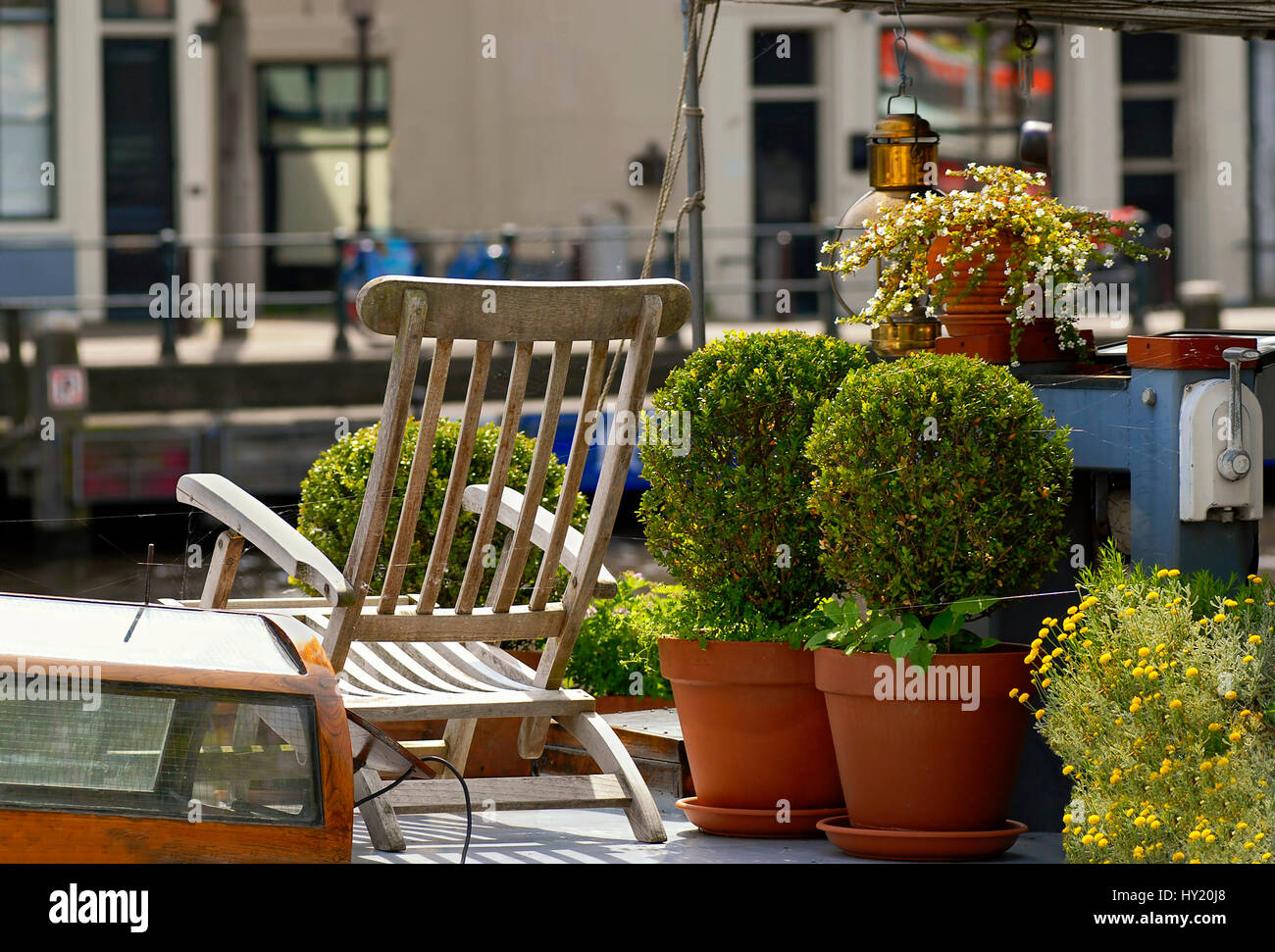 Detail Image of House Boat Terrace with flower pots and sunchair in Amsterdam, Holland. Stock Photo