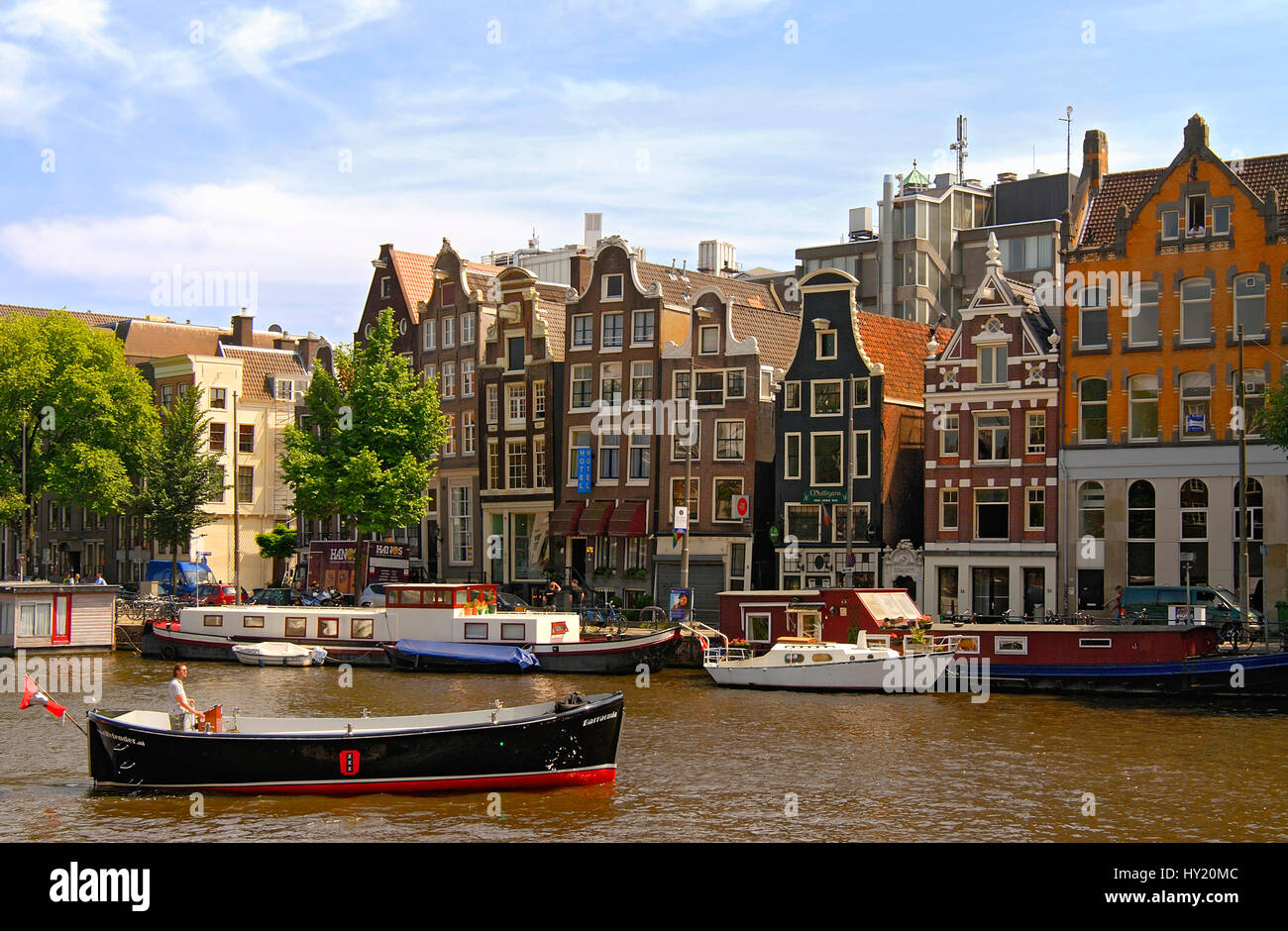 Image of small motor boat driving in a water channel in the inner city of Amsterdam, Holland. Stock Photo