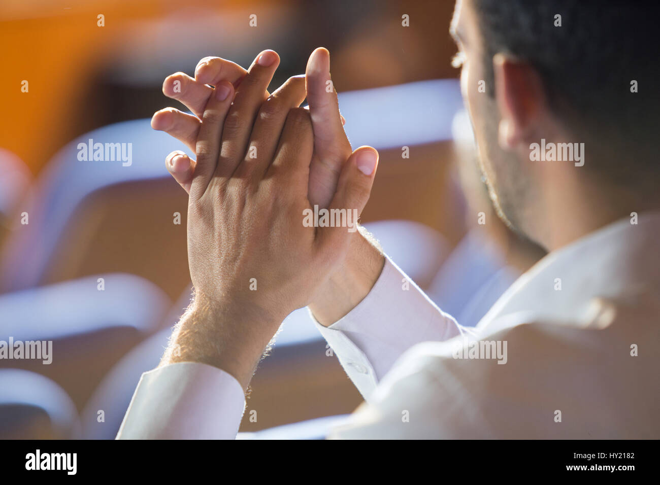 Business executive clapping while listening to speech at conference center Stock Photo