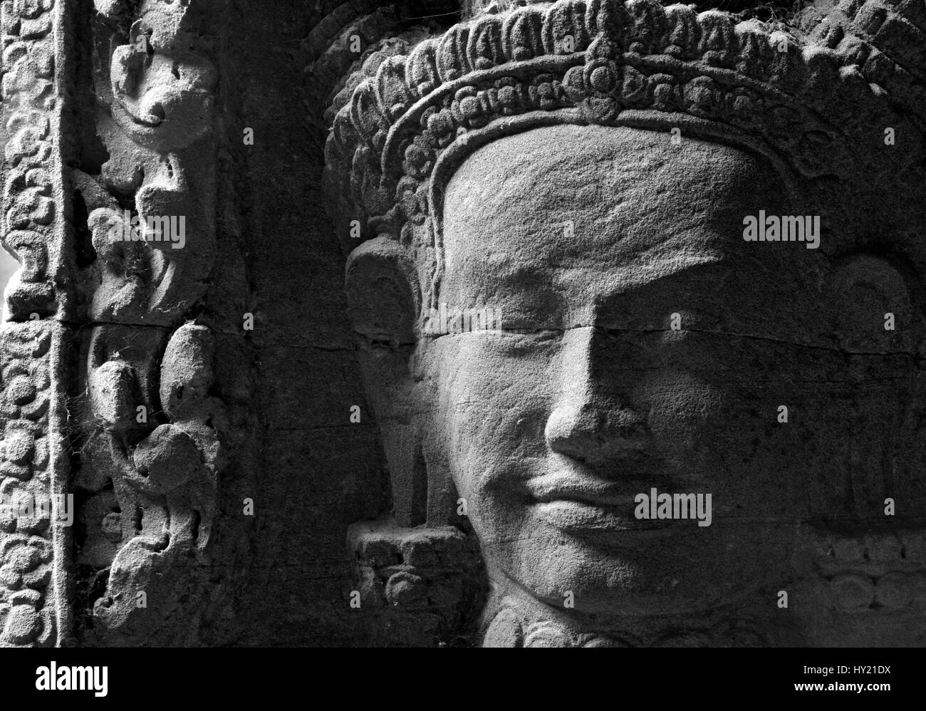 This stock photo shows a close up of a stone carving of a face at the famous Angkor Wat Temple near Siam Reap in Cambodia. The image shows the typical Stock Photo