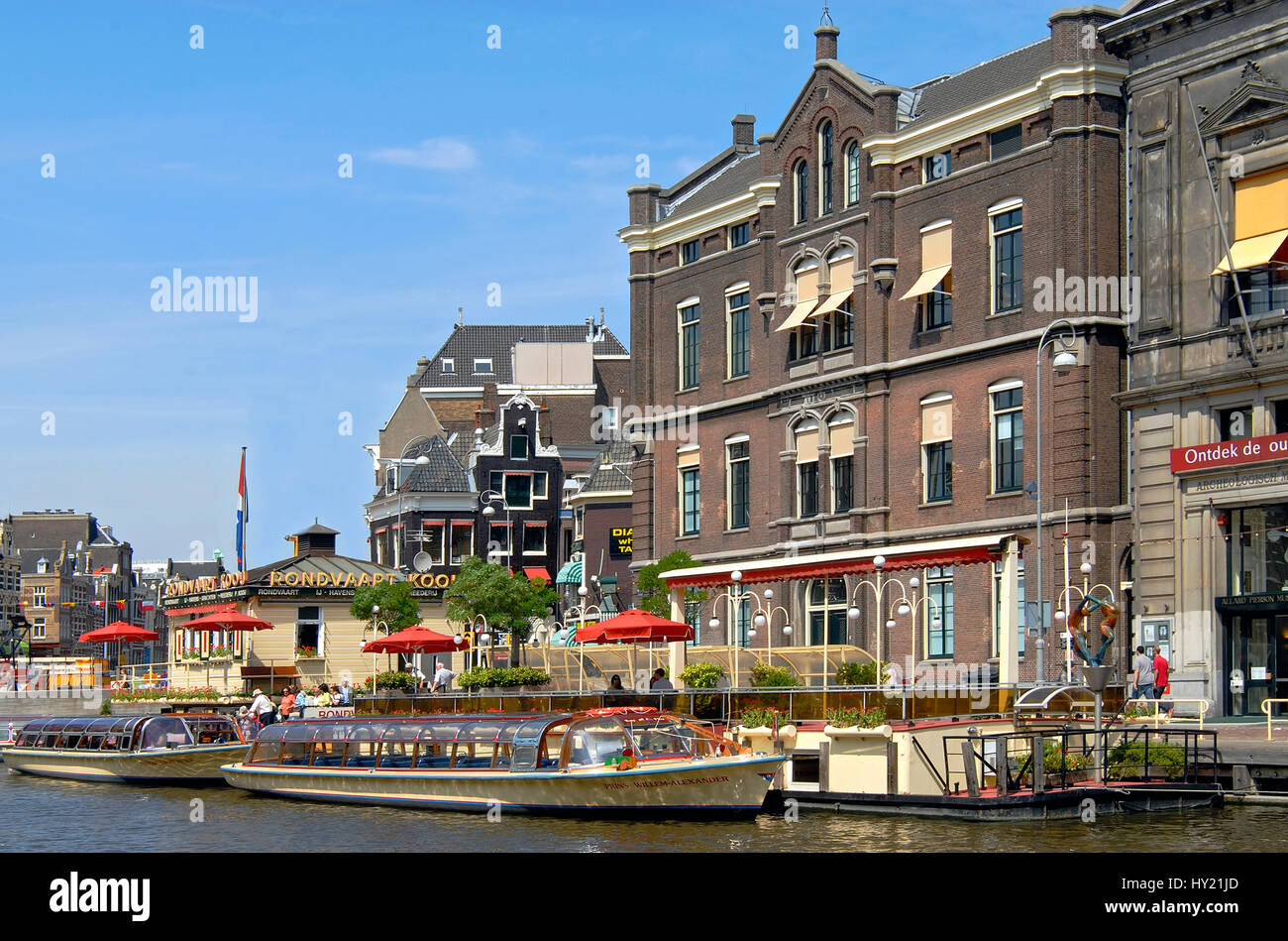 Image of typical sightseeing boats in a water channel in the inner city of Amsterdam, Holland. Stock Photo
