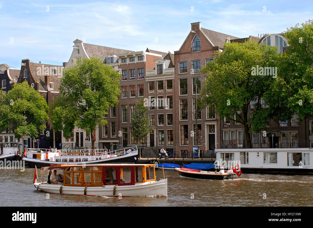 Image of small motor boats in a water channel in the inner city of Amsterdam, Holland. Stock Photo