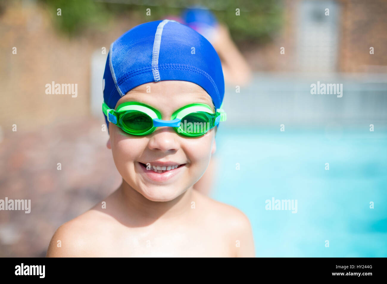 Close up portrait of little boy wearing swimming goggle and cap at