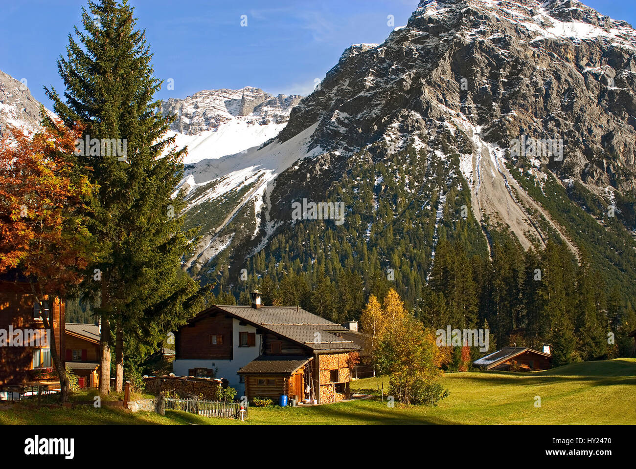 This stock photo shows a typical Swiss wooden house in a Autumn landscape at the small mountain village of Arosa a ski resort in Switzerland. Arosa is Stock Photo