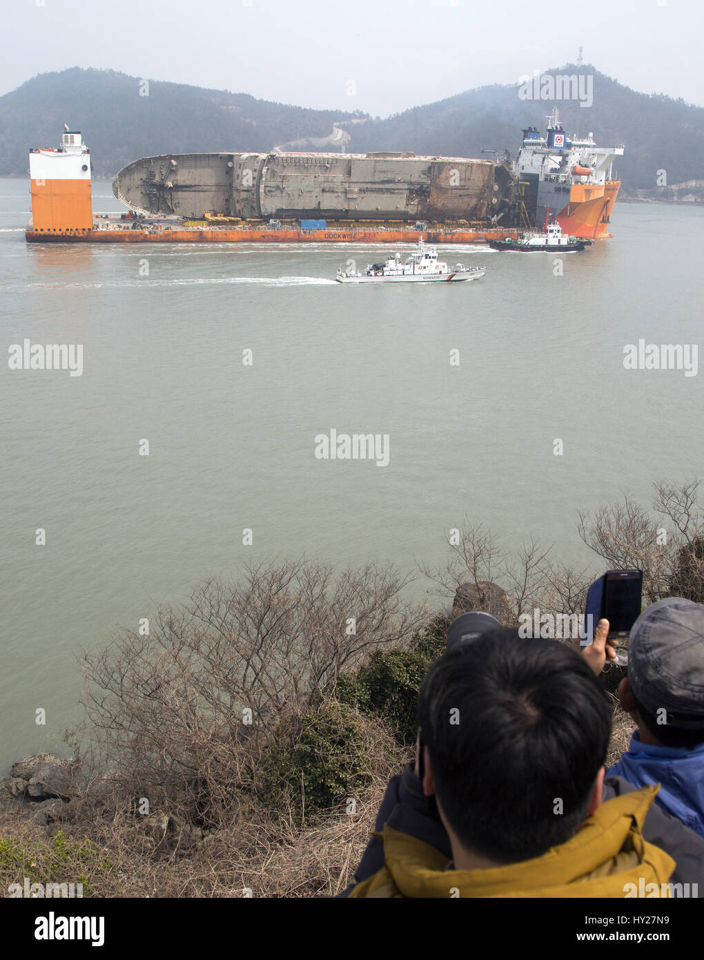 Mokpo, South Korea. 31st March 2017. South Korea's Coast Guard vessels escort semi-submersible ship Dockwise White Marlin carrying Sewol Ferry en route to Mokpo New Port in Mokpo, about 311 km (193 miles) south of Seoul, South Korea. The Sewol Ferry sailed into the port on Friday, about three years after it sank off South Korea's southwestern coast near Jindo on April 16, 2014 during a journey from Incheon to Jeju. The Ferry was carrying 475 crew and passengers, mostly high school students on a school trip. b Credit: Aflo Co. Ltd./Alamy Live News Stock Photo