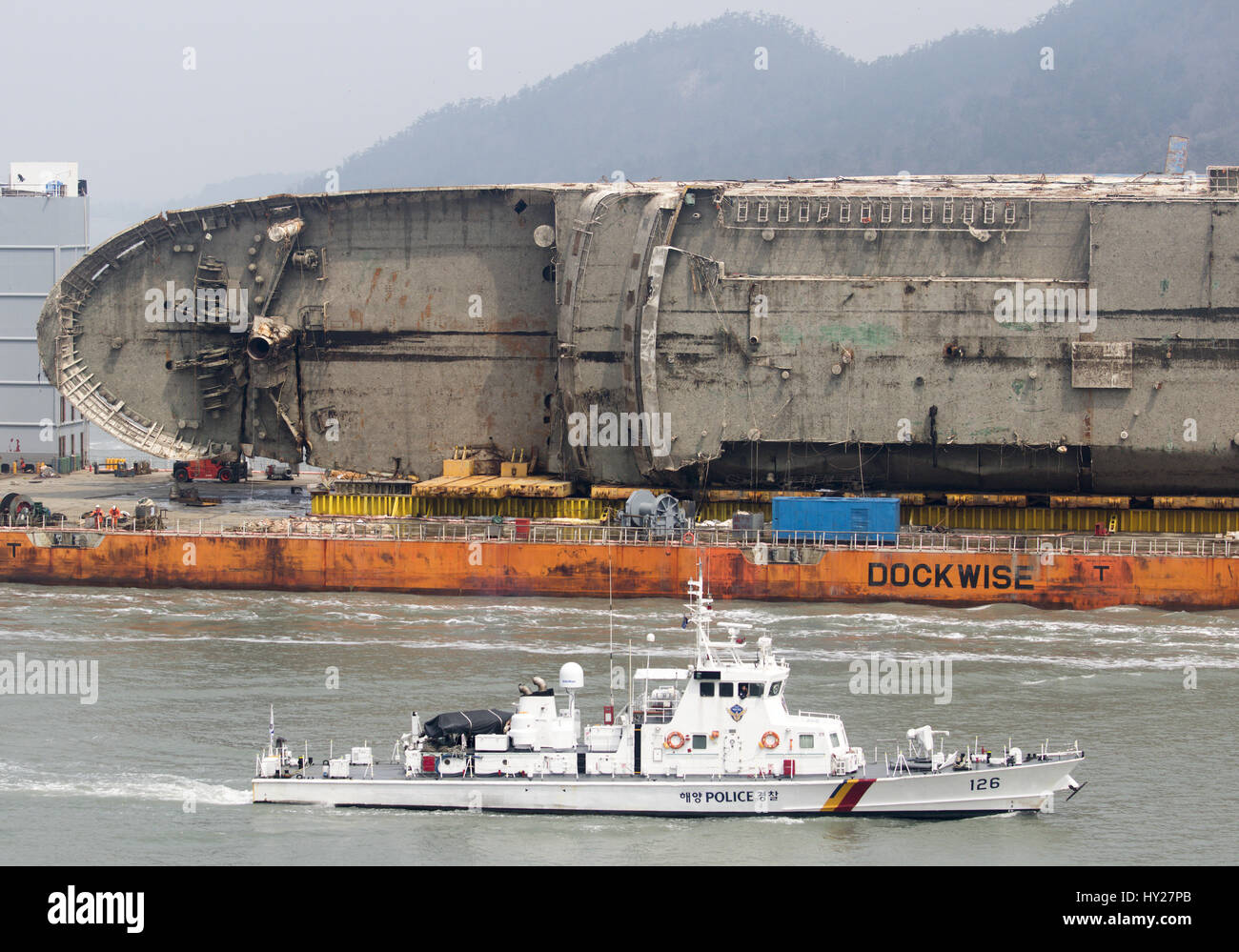 Mokpo, South Korea. 31st March 2017. A South Korea's Coast Guard vessel escorts semi-submersible ship Dockwise White Marlin carrying Sewol Ferry en route to Mokpo New Port in Mokpo, about 311 km (193 miles) south of Seoul, South Korea. The Sewol Ferry sailed into the port on Friday, about three years after it sank off South Korea's southwestern coast near Jindo on April 16, 2014 during a journey from Incheon to Jeju. The Ferry was carrying 475 crew and passengers, mostly high school students on a school trip. Credit: Aflo Co. Ltd./Alamy Live News Stock Photo