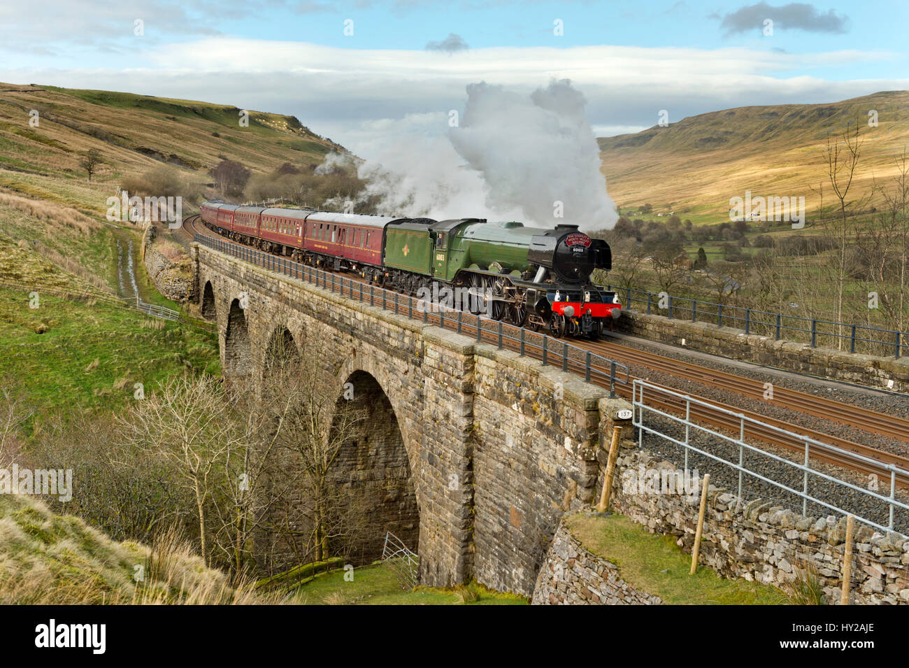 Cumbria, UK. 31st Mar, 2017.  The Flying Scotsman passes over Ais Gill Viaduct near the summit of the Settle-Carlisle railway line, 31st March 2017. The journey over the line, from Oxenhope via Skipton to Carlisle and return, marks the first day of its re-opening following closure for over a year. The closure was caused by a major landslip near Appleby. Credit: John Bentley/Alamy Live News Stock Photo