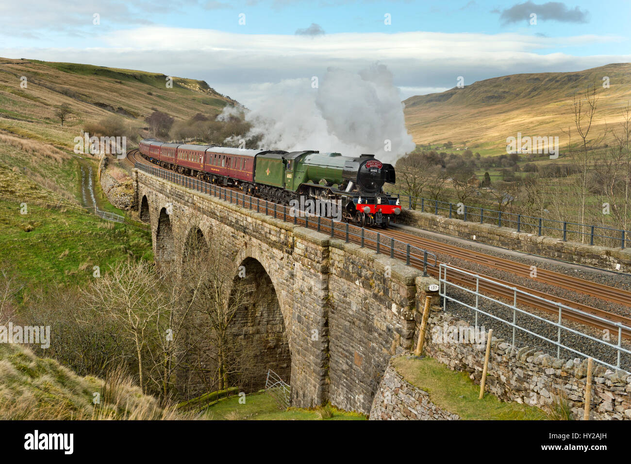 Cumbria, UK. 31st Mar, 2017.  The Flying Scotsman passes over Ais Gill Viaduct near the summit of the Settle-Carlisle railway line, 31st March 2017. The journey over the line, from Oxenhope via Skipton to Carlisle and return, marks the first day of its re-opening following closure for over a year. The closure was caused by a major landslip near Appleby. Credit: John Bentley/Alamy Live News Stock Photo