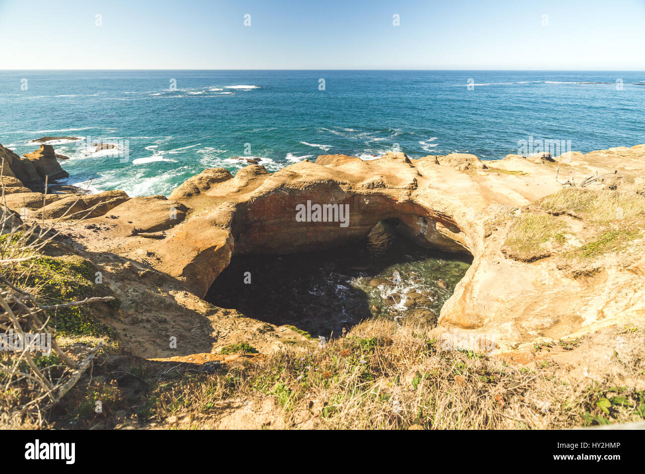 Sunny summer day at Devil's Punch Bowl State Park near Newport, Oregon, USA. Ocean waves and