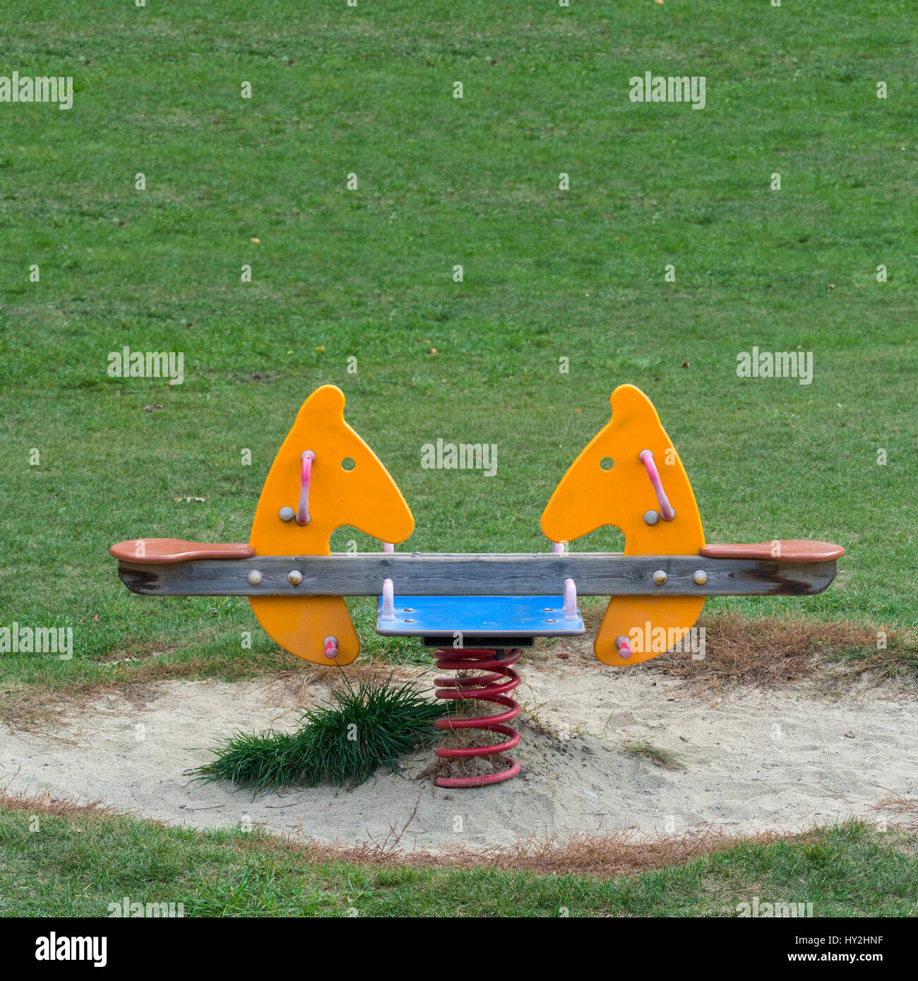 Double seats rocking spring Horse in the meadow of a Playground Stock