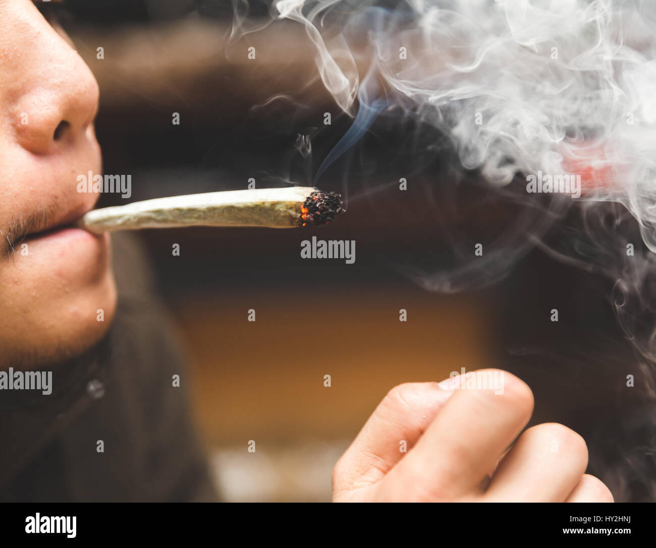 Man smoking joint, cigarette, or spliff. Stock Photo