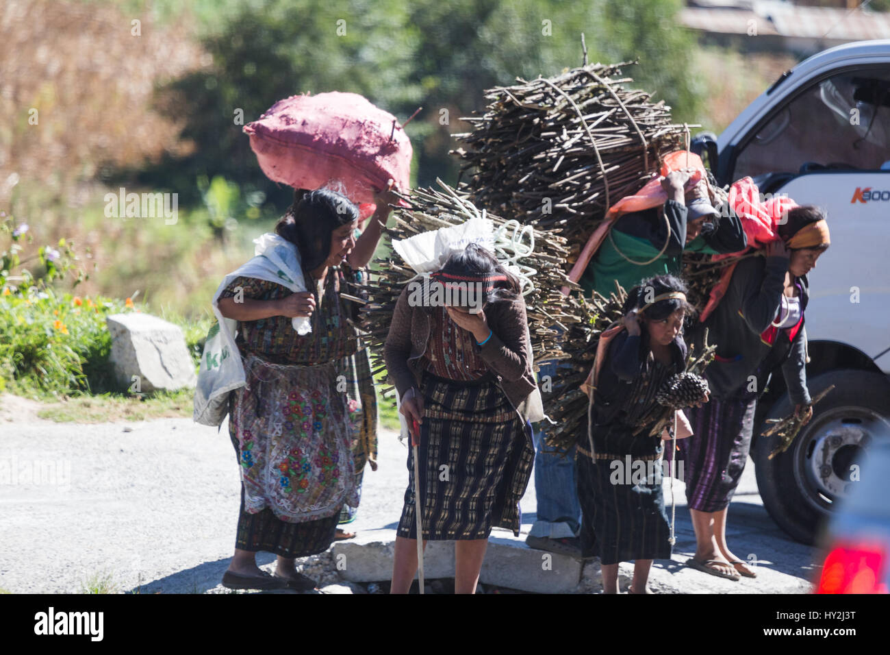 Women carrying loads of wood and other supplies while working in Guatemala. December 29, 2014. Stock Photo
