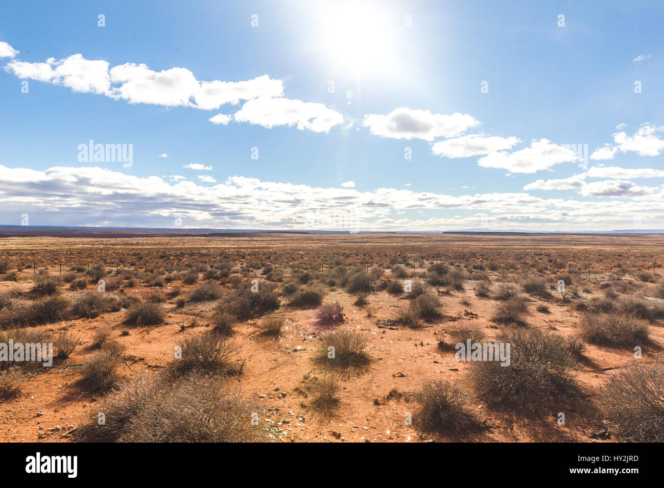 Bright sun shining in blue sky over desert landscape. Northern Arizona, USA. Stock Photo