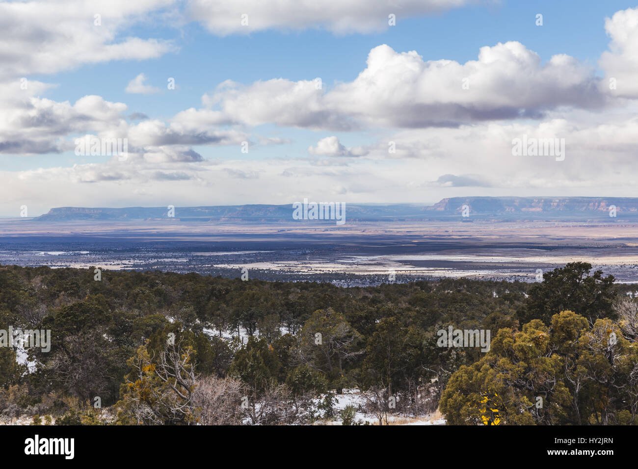 Desert landscape with clouds over mesas. Winter day with snow on ground. Stock Photo