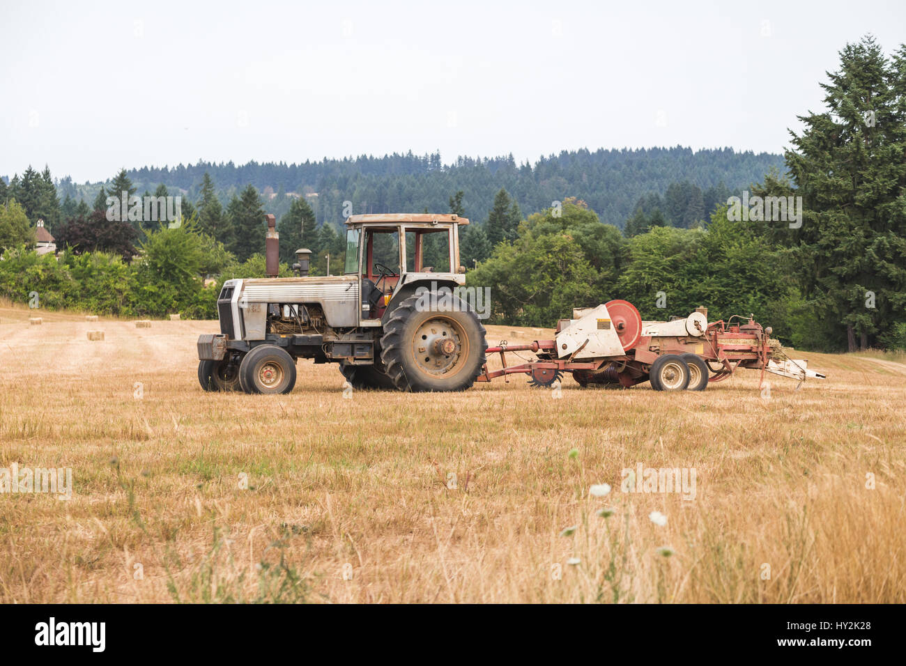 Antique or vintage tractor with heavy equipment attached in a field in rural Oregon, USA. Stock Photo