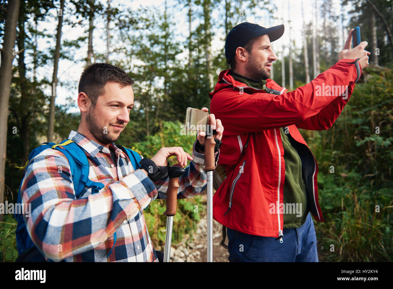 Two hikers taking photos of nature Stock Photo - Alamy