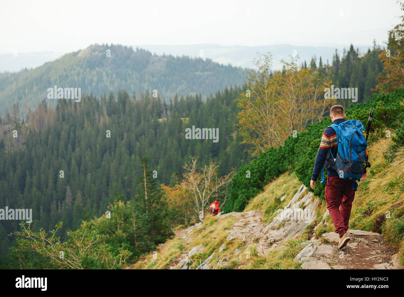 Hikers making their way down a rocky trail in the mountains Stock Photo