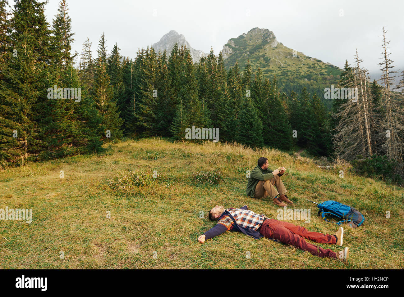 Exhausted hikers lying on grass after a trek Stock Photo