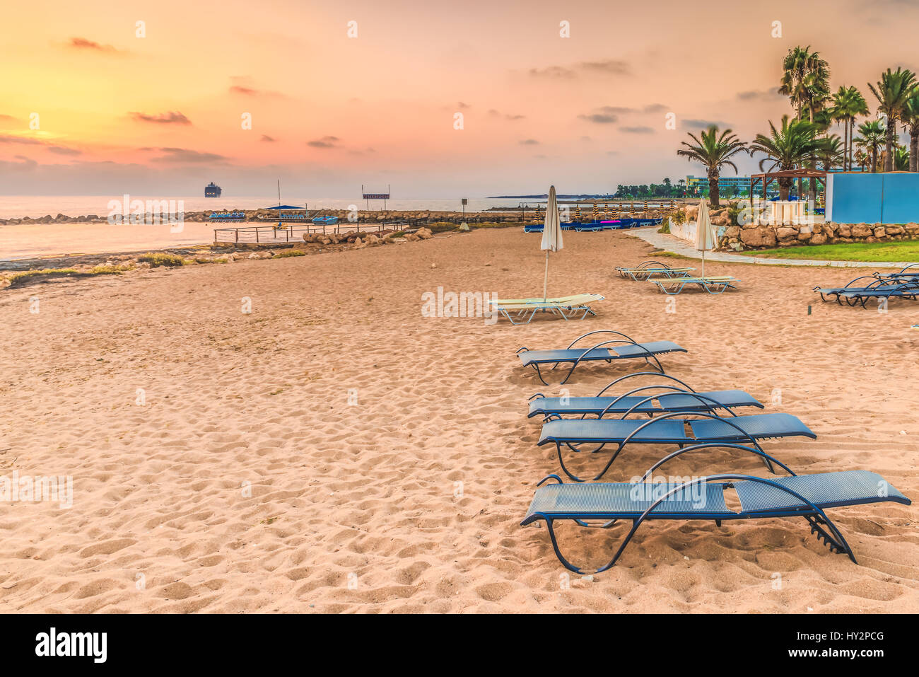 Sunset on the beach in the town of Paphos, Cyprus. View of the Mediterranean Sea and the coastline. Stock Photo