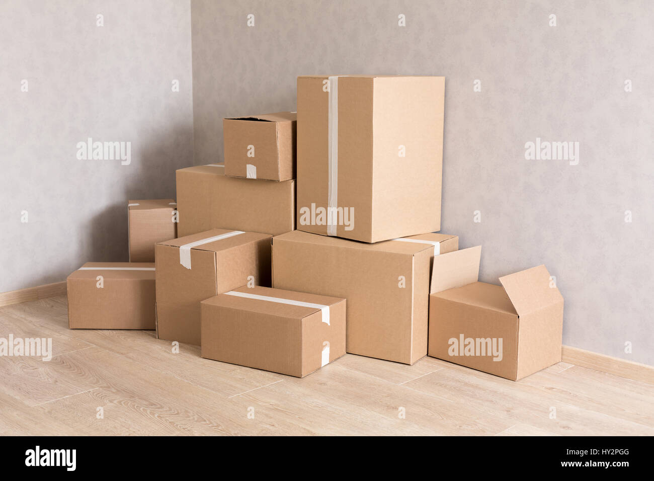 Moving boxes pile in new empty room Stock Photo