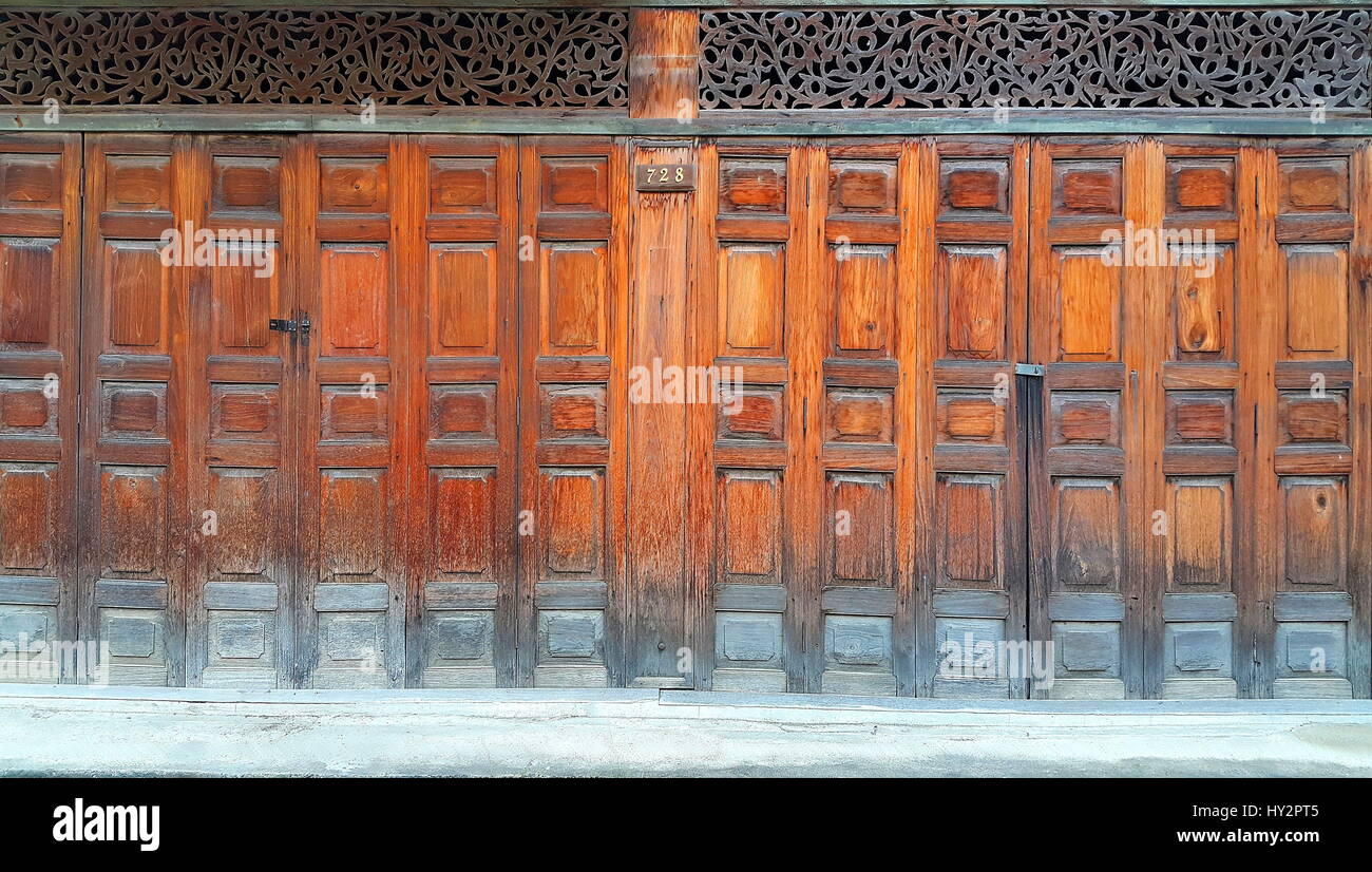 Old style wooden Chinese folding doors decorated by traditional carved wood with latch Stock Photo
