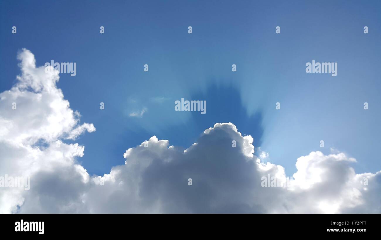 Blue sky background with white clouds and sun ray Stock Photo - Alamy