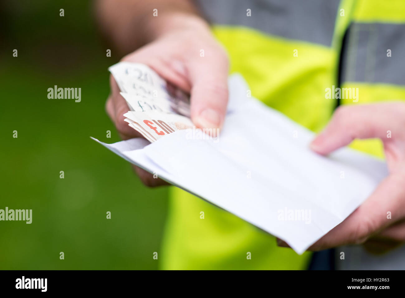 A workman builder being paid cash in hand Stock Photo