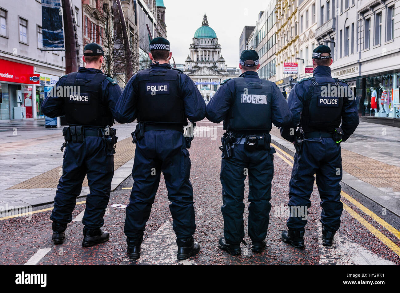 Four PSNI police officers prevent people proceeding up Donegal Place in advance of a Parade passing through Belfast City Centre Stock Photo