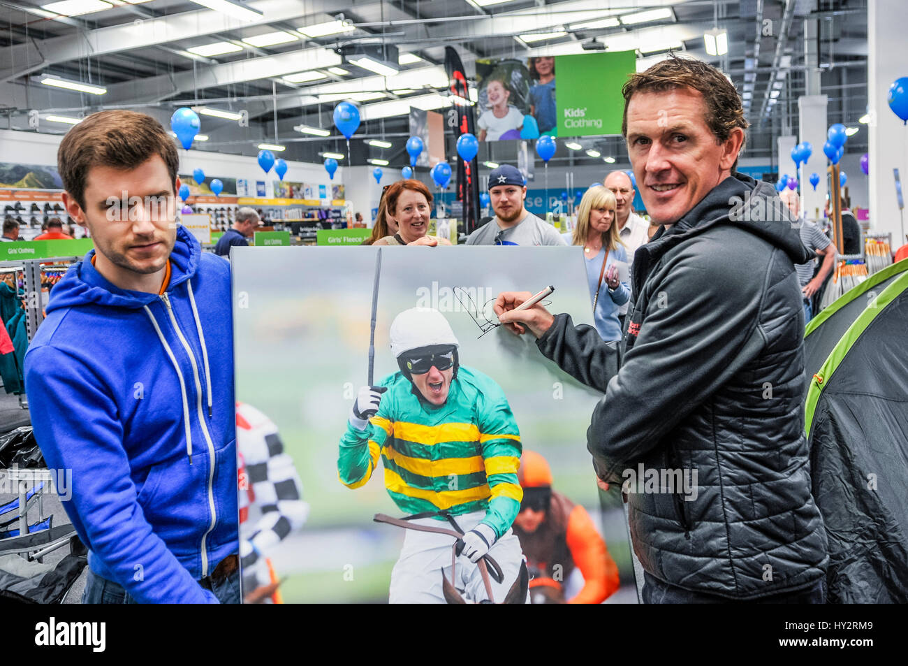 NEWTOWNABBEY, NORTHERN IRELAND. 14 MAY 2016 - Champion Jockey AP McCoy signs a portrait of him as he opens the first Go Outdoors store in Ireland. Stock Photo