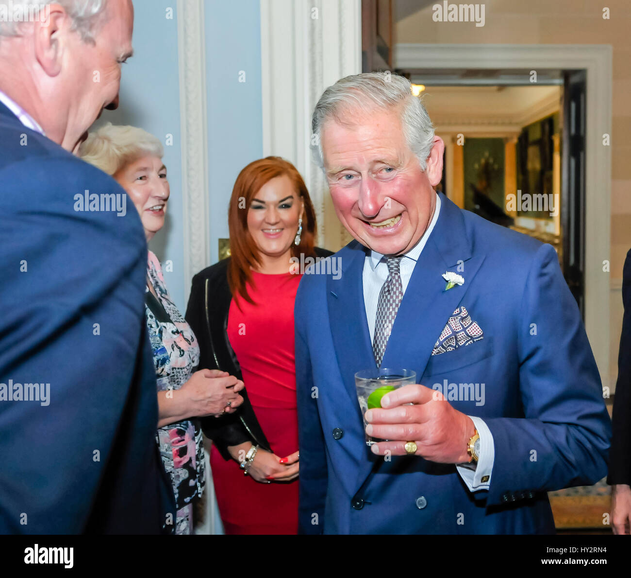 HILLSBOROUGH, NORTHERN IRELAND. 24 MAY 2016: HRH Prince Charles, the Prince of Wales, shares a joke with guests in Hillsborough Palace over a gin and tonic. Stock Photo
