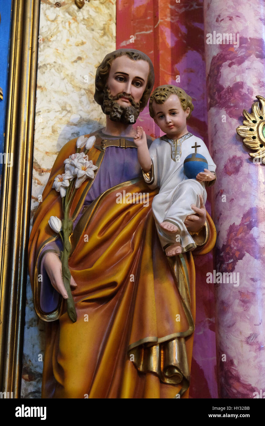 Saint Joseph holding baby Jesus statue at the altar in the church of