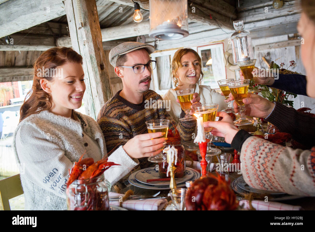 Sweden, People raising toast during crayfish party Stock Photo