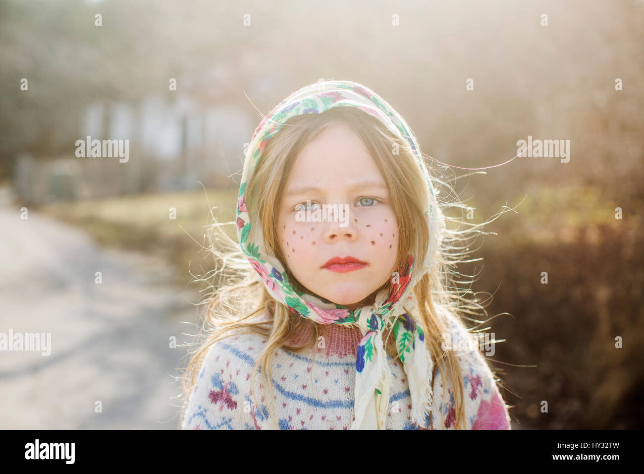 Sweden, Portrait of girl (4-5) dressed up as Easter witch wearing headscarf Stock Photo