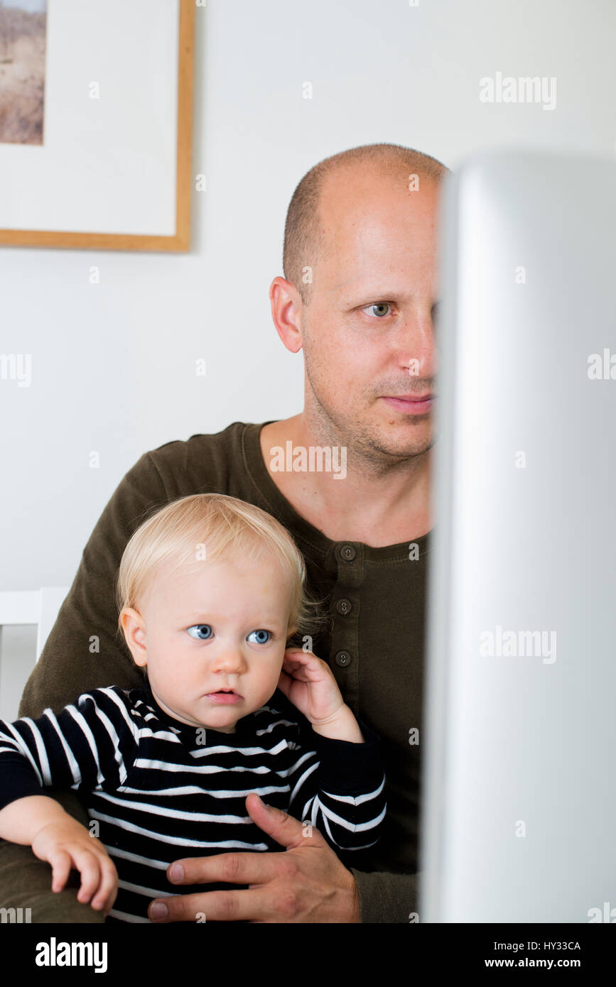 Father and son looking into computer hi-res stock photography and ...