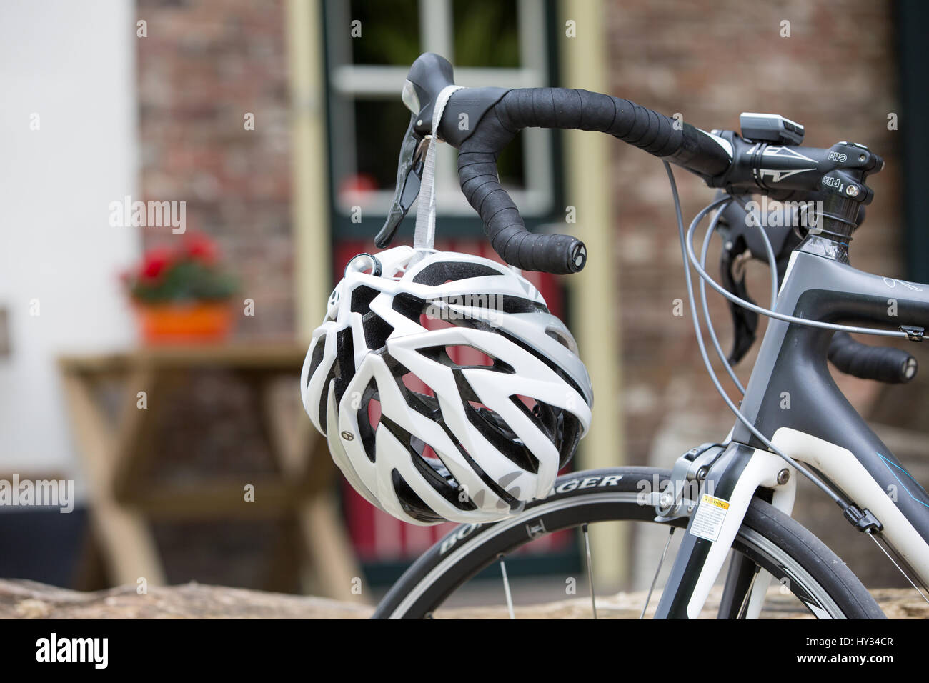 Detail of a bicycle helmet hanging on a steering wheel of a parked