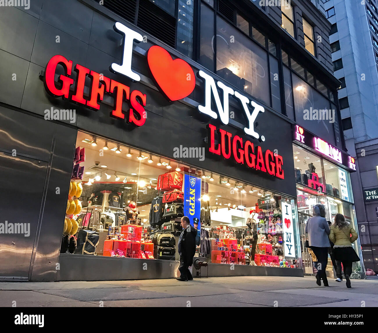 People walk by an "I HEART NY" gifts and luggage store located near