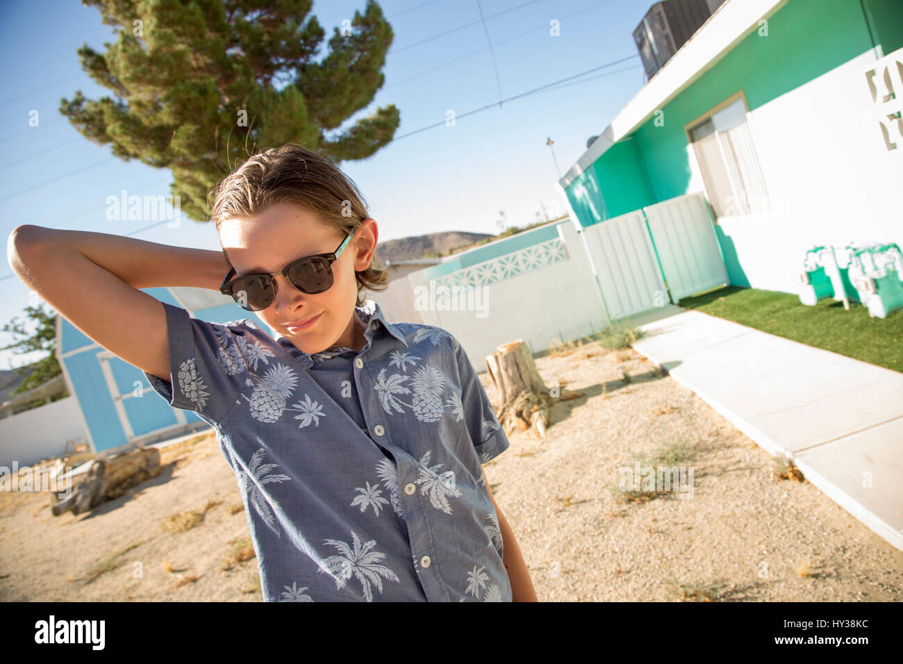 USA, California, Boy (14-15) wearing sunglasses standing outside of house Stock Photo