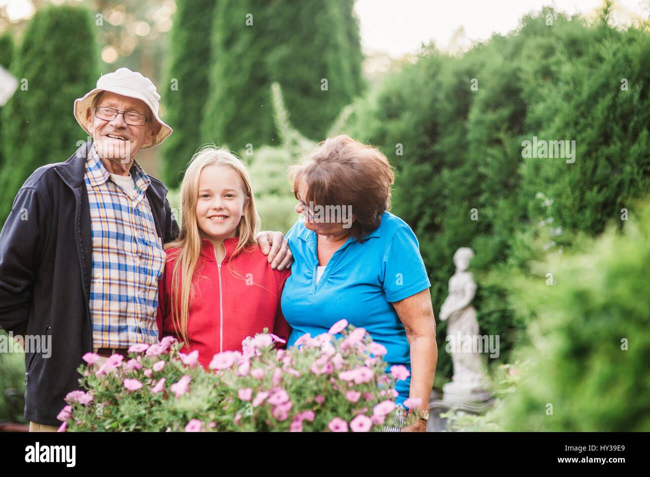 Sweden, Vastmanland, Hallefors, Bergslagen, Girl (12-13) with grandparents posing in garden Stock Photo