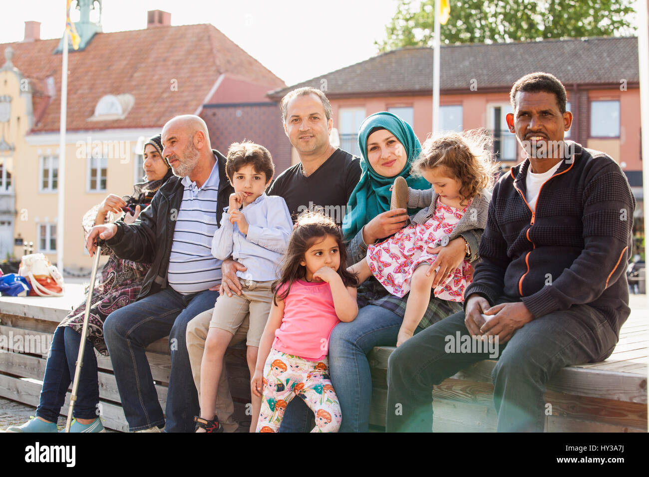 Sweden, Blekinge, Solvesborg, Portrait of family with children (2-3, 4-5, 6-7) sitting on brick wall Stock Photo