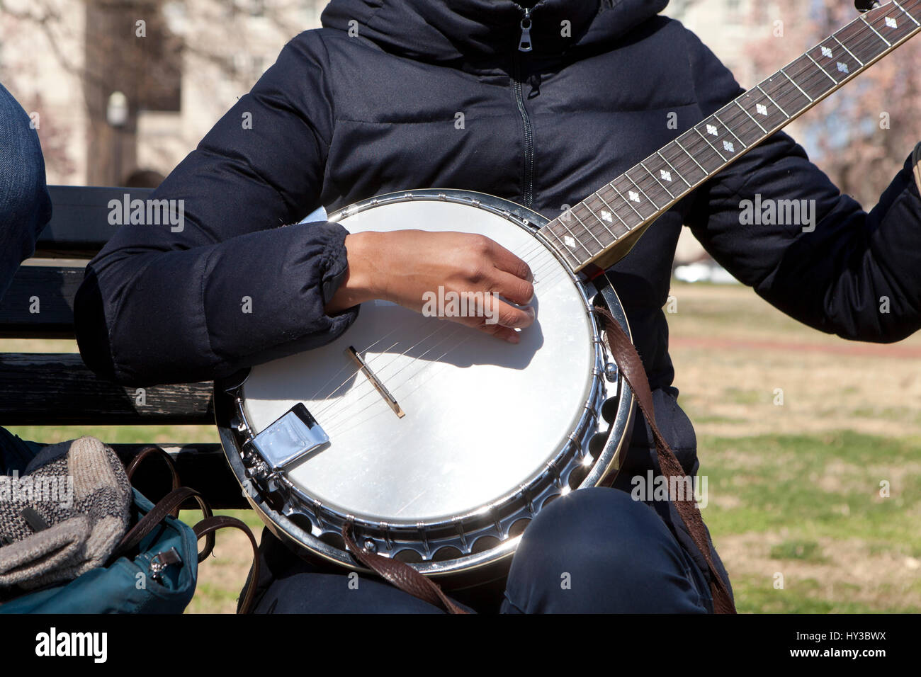 African-American woman playing banjo in a public park  USA Stock Photo