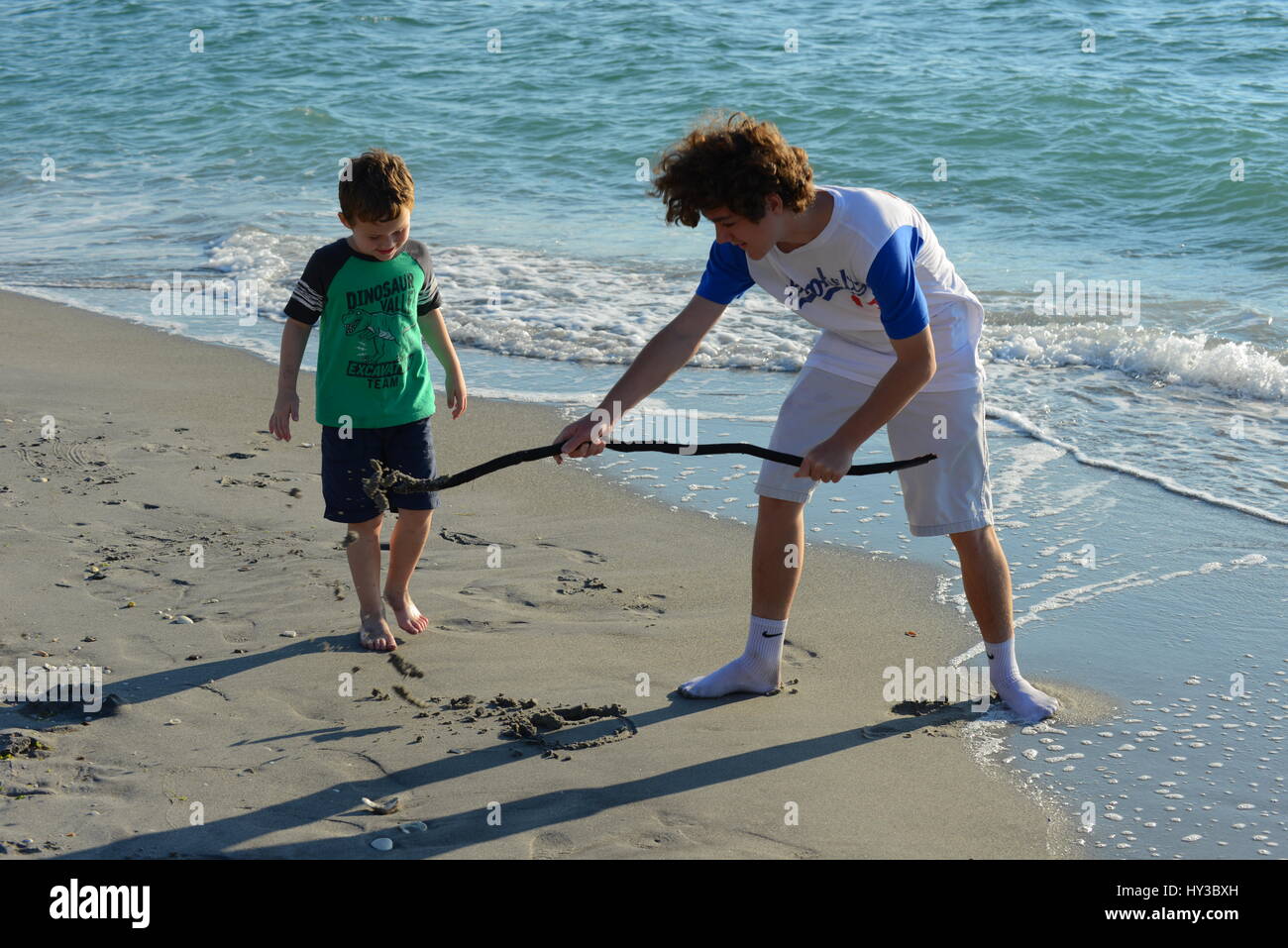 young boys with stick  at the beach Stock Photo